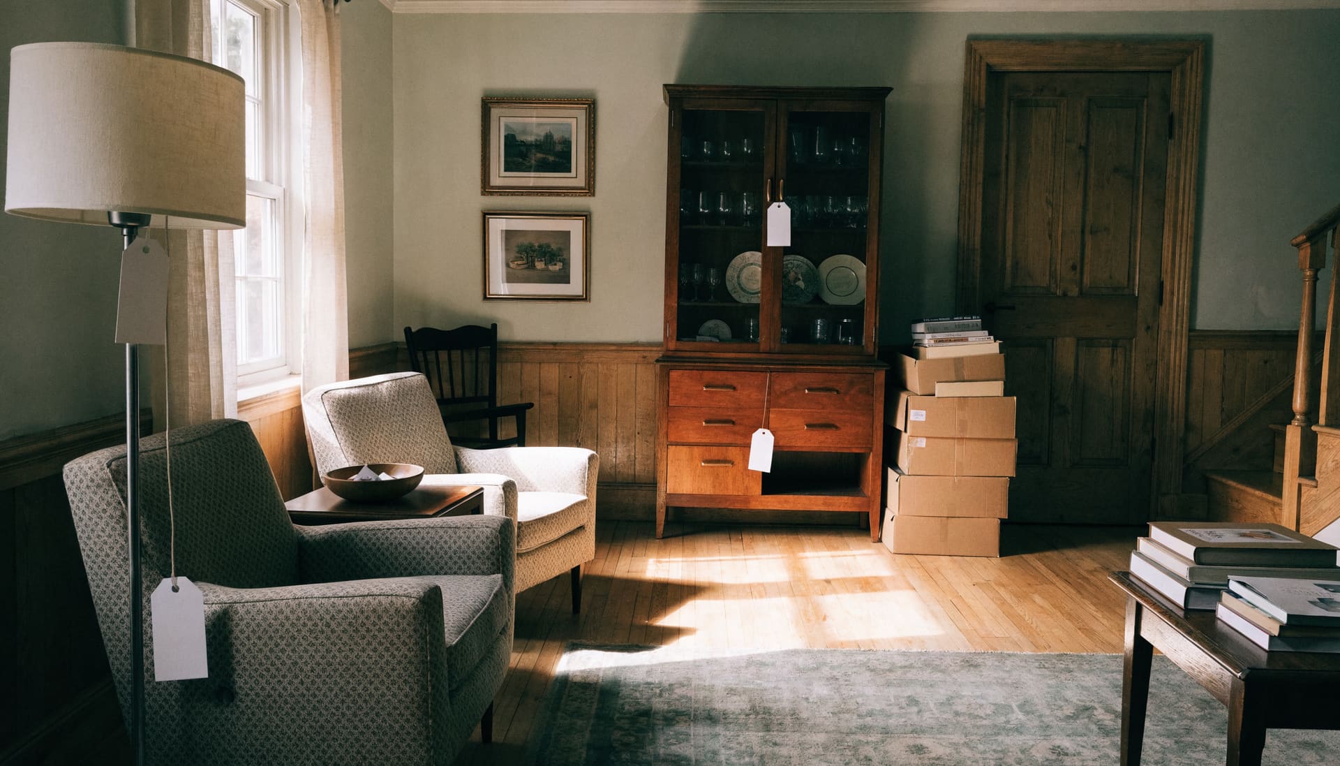 A furnished living room with a sideboard, armchairs and tagged pieces prepared for an estate auction (representative image)