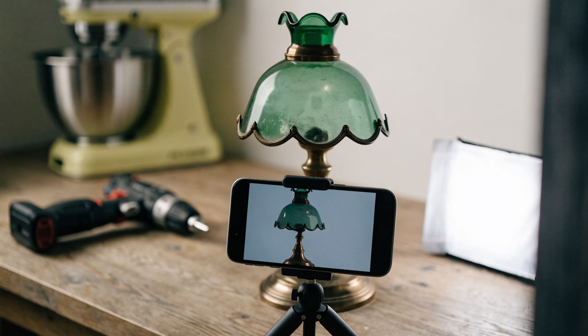 A phone on a small tripod photographing a vintage lamp for an online listing (representative image)